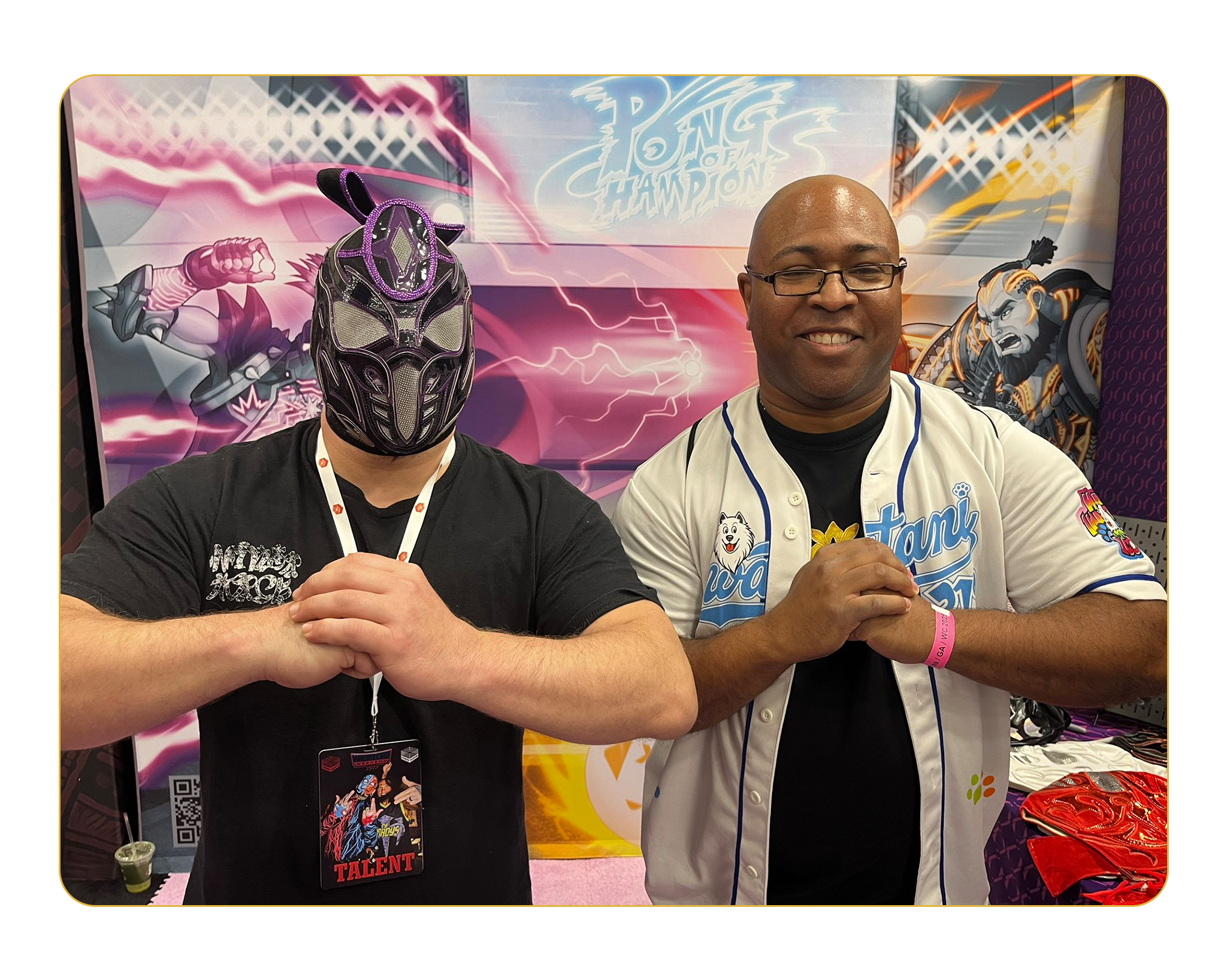 Ninja Mack posing with fan in front of pong of champions booth